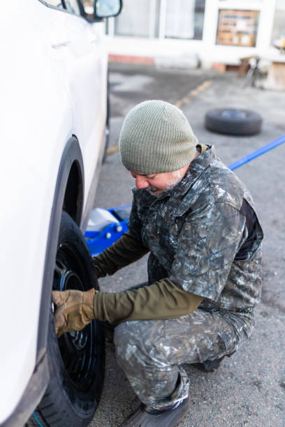 istock Man changing regular tires to winter studless tires at home 1442150382