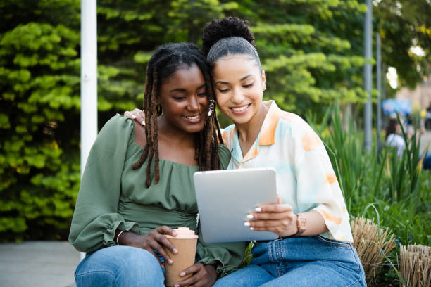 istock Two happy best friends using tablet in the park 1442151105