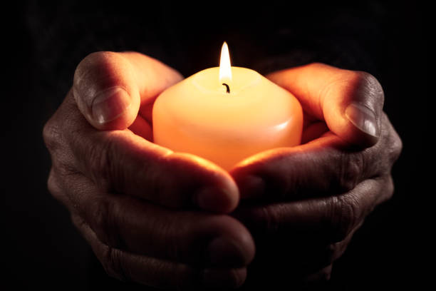 prière et culte tenant une bougie allumée dans les mains - candle memorial vigil praying candlelight photos et images de collection