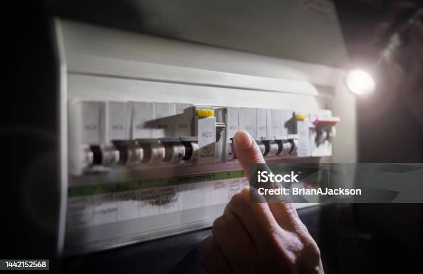 Electricity Power Outage Emergency Turning On Or Off Circuit Breaker On Electrical Fuse Board Stock Photo - Download Image Now