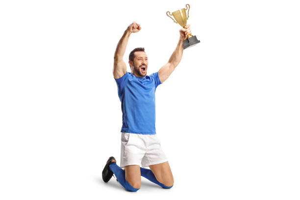 istock Football champion holding a trophy and kneeling 1442155253