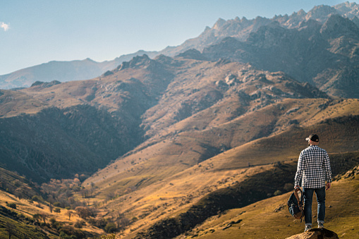 Standing at the edge and watching beautiful valley in the mountains