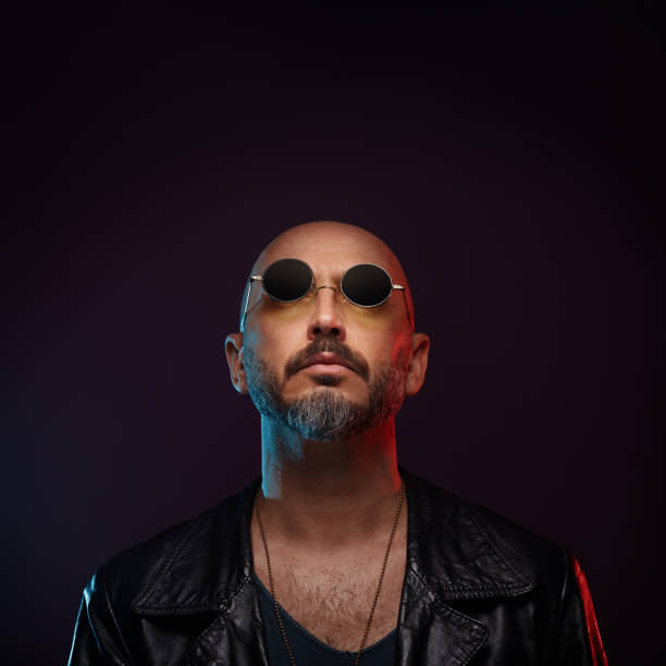 istock Stylish bald man wearing leather jacket with round sunglasses looking up 1442159131