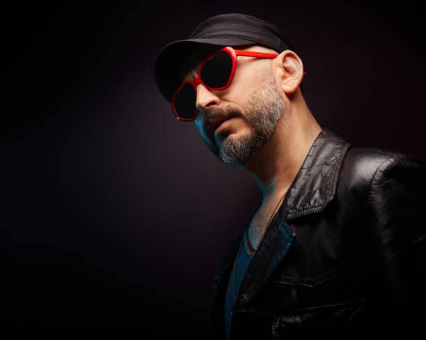 istock Stylish handsome man wearing leather jacket with heart shaped red sunglasses 1442159146