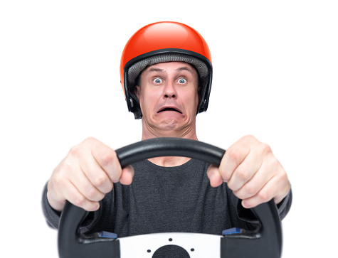 Emotional scared man in red motorcycle helmet holding steering wheel with open mouth, isolated on white background. File contains a path to isolation.