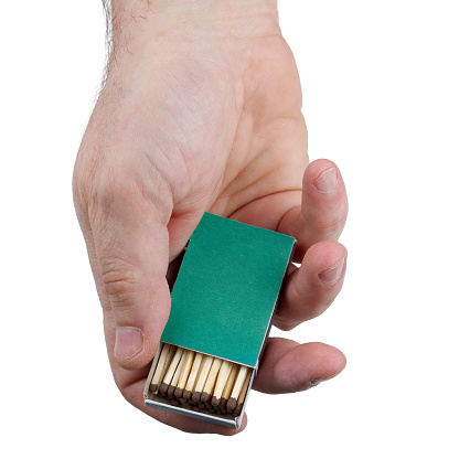 Close up of human hands with open green matchbox isolated on white background with clipping path