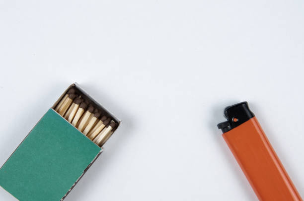 istock Open grenn matchbox and orange plastic gas lighter on white background 1442165736