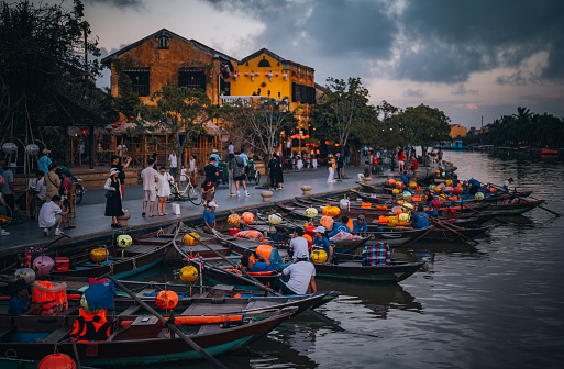 Hoi An Vietnam - November  16, 2022: Hoi An at dusk with boats cruising on river side with lantern.