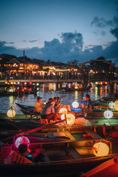 Hoi An At Dusk Hoi An Vietnam - November  16, 2022: Hoi An at dusk with boats cruising on river side with lantern. thu bon river stock pictures, royalty-free photos & images