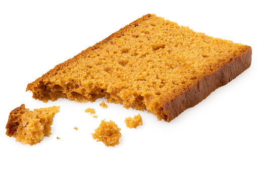 Partially eaten slice of spiced honey cake with crumbs isolated on white.