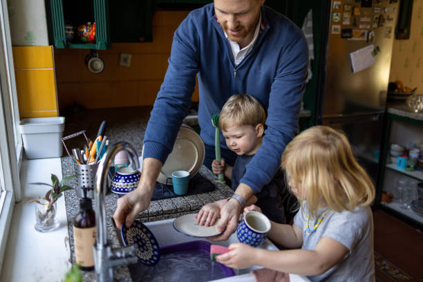 crianças ajudando o pai a lavar pratos na cozinha - stay at home dad - fotografias e filmes do acervo
