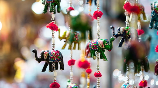Beautiful colorful handmade wind chimes with bells, decorated toy elephant model Rajasthan India. Decorative door, wall hangings with mirror and beads on Dussehra, Dasara, Diwali festival at Dili Haat