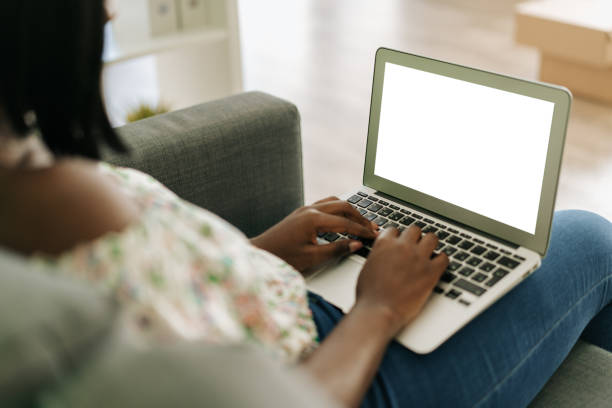 istock Young african woman working on laptop computer at home sitting on sofa. 1442172736