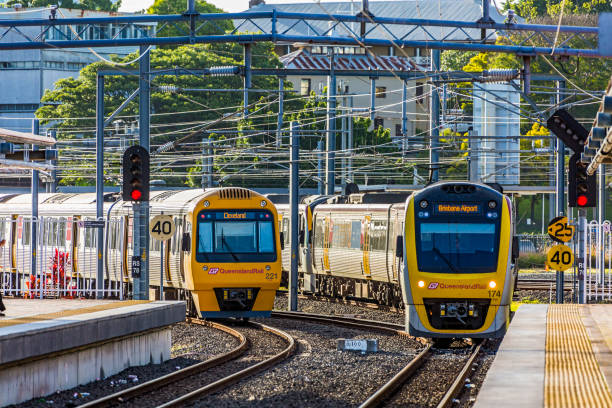Queensland Rail electric trains arriving and departing Brisbane's Roma Street Station Brisbane, Australia - Nov 20, 2017: A Queensland Rail peak hour service to Brisbane Airport arrives at Brisbane's Roma Street Station as a service to suburban Cleveland departs. Electric commuter trains passing under maze of electric overhead wires. speed limit sign australia stock pictures, royalty-free photos & images