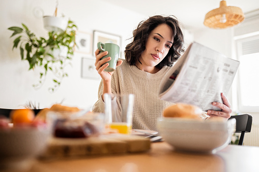 Woman relaxing and having breakfast at home