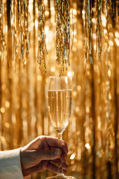 verre de champagne dans la main de l’homme contre luxe lueur dorée décoration pluie chère fête de vacances - polish bread photos et images de collection