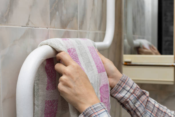 istock woman hangs a towel on a heated towel rail 1442183286