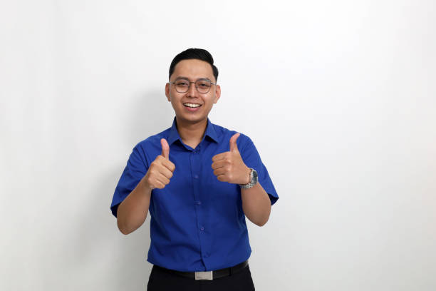 istock Young asian man standing while showing thumbs up. Isolated on white background 1442184075