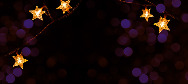 Merry Chrsitmas celebration decoration holiday background banner  - Golden star light chain hanging on dark night sky with bokeh