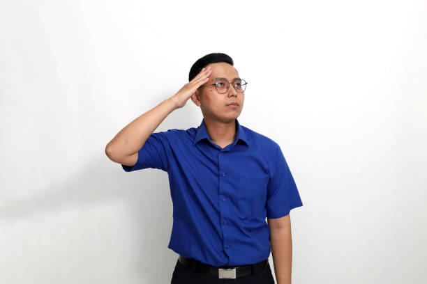 National Anthem is played. Army Ranger from Special Troops Battalion in universal Camouflage pattern Uniforms and Tan beret with Ranger Regiment crest is standing to attention and saluting proudly with honor and respect. Service to his country concept. National holidays, Veterans Day, Memorial Day