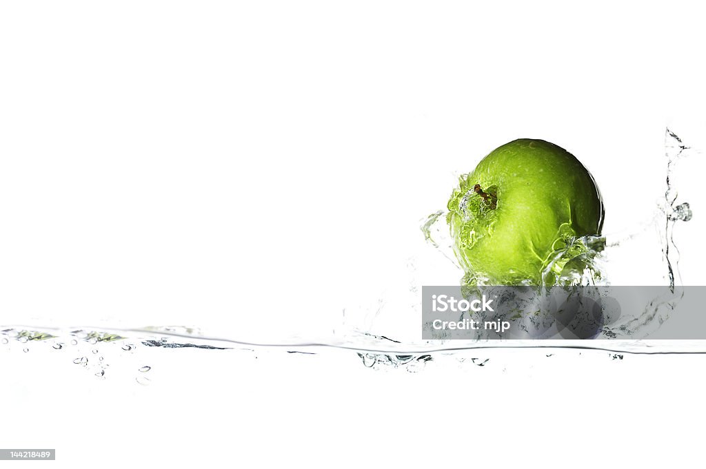 A green apple splashing in clear water Isolated green apple surfing on the big wave. Adult Stock Photo