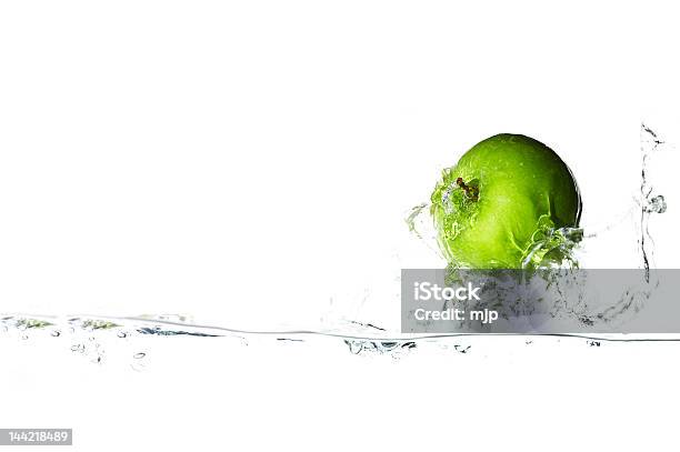 A Green Apple Splashing In Clear Water Stock Photo - Download Image Now - Adult, Apple - Fruit, Breaking Wave