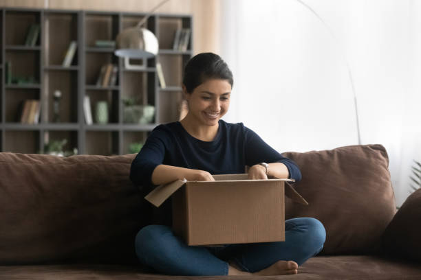istock Excited Indian woman unpack box with internet order 1442186899