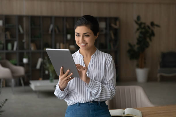 istock Smiling Indian woman use tablet browsing internet 1442187016