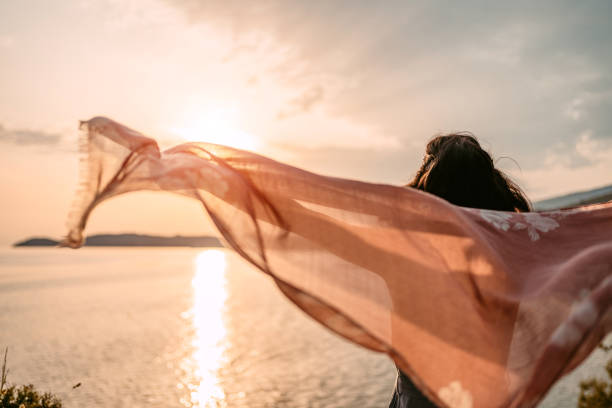 istock Young Woman Spreading Her Arms While Holding A Scarf At The Beach 1442190290
