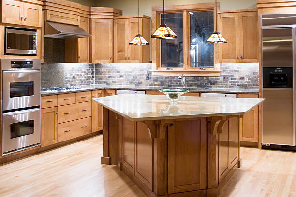 A wood kitchen with island and steel appliances