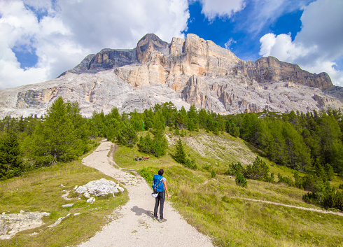 Dolomiti, Italy - 30 August 2022 - A view of Dolomites mountain range, UNESCO world heritage site, in Veneto and Trentino Alto Adige regions. Here the Sasso della Croce with girl hiker