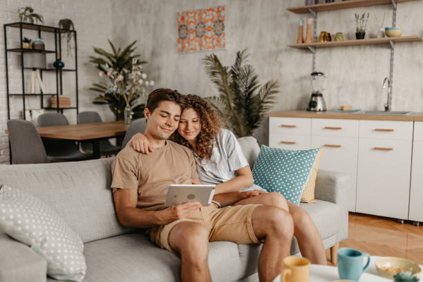 istock Young Couple Sitting On The Sofa And Using Tablet 1442192925