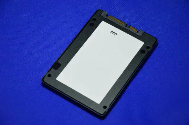 Photo of 2.5 inch SSD hard drive laid on a blue background.