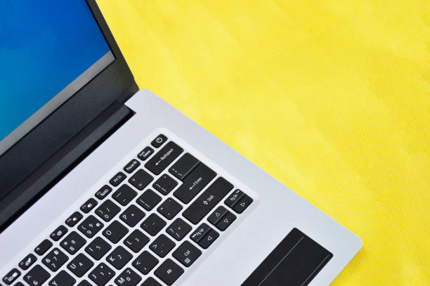 istock top right view of white laptop on yellow background 1442194742