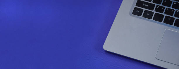 istock Left view of a white laptop on a blue background. 1442194780