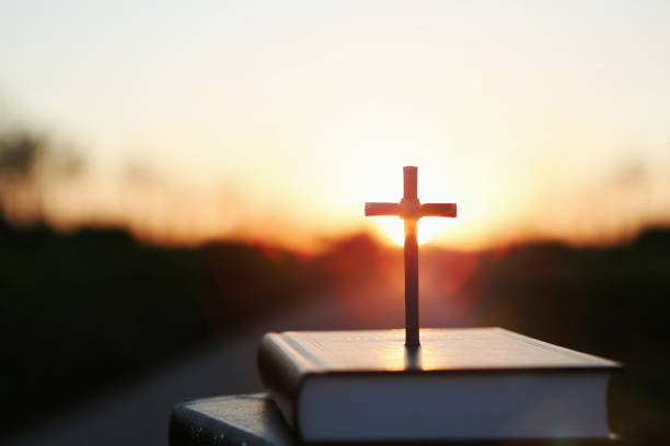 el sol crepuscular, la biblia y la santa cruz de jesucristo - morning prayer fotografías e imágenes de stock