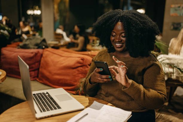 istock Woman using smartphone and laptop at cafe 1442195738