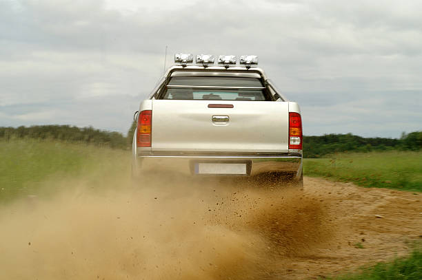 Having fun on gravel Back wiev of a pickup truck drifting on gravel road off road vehicle photos stock pictures, royalty-free photos & images