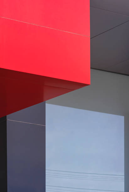 istock Geometric pattern background of red aluminium composite tile wall decoration with light reflection on glass surface of modern gray building wall 1442196534