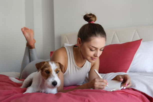 Young woman and her dog on the bed. stock photo