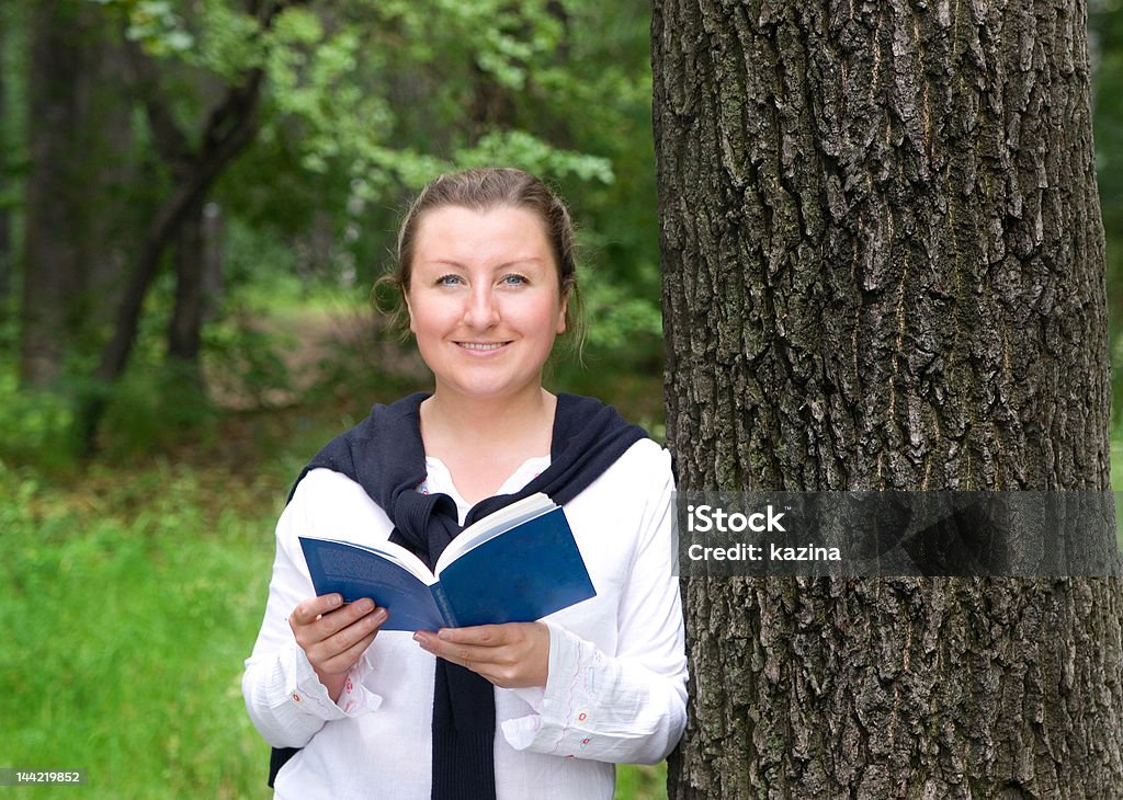 Ragazza con libro nel parco - Foto stock royalty-free di 20-24 anni