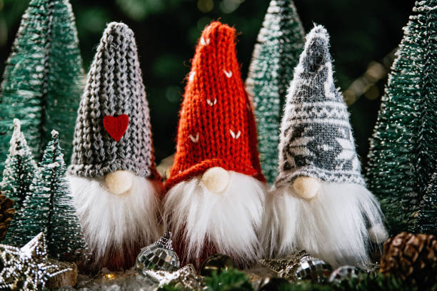 Christmas composition with gnome and festive decorations on wooden background.