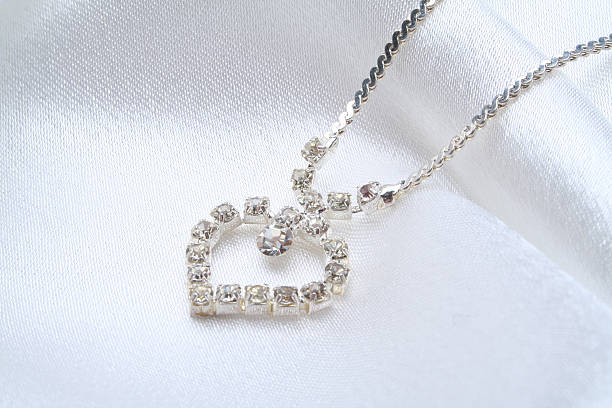 weibliche juwelier ornamente auf einem hintergrund - necklace jewelry diamond silver stock-fotos und bilder