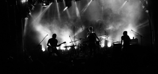 The silhouette of a rock band performing on stage.