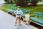 istock Baby brother and sister have fun in public park at eighties 1442205205