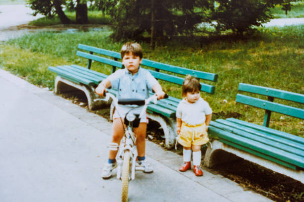 irmão e irmã do bebê se divertem no parque público aos anos oitenta - 1980s style fotos - fotografias e filmes do acervo