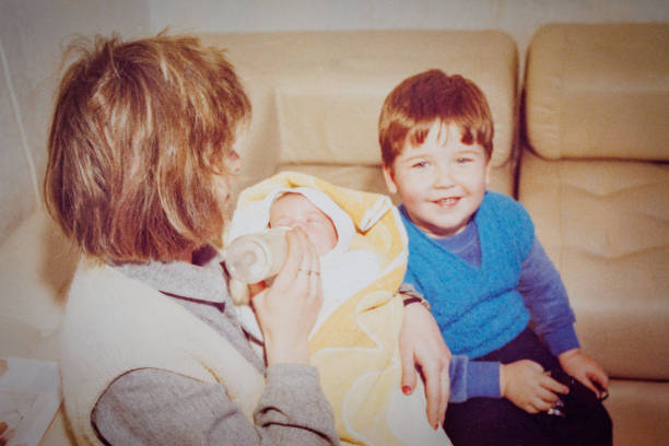 istock Mother feeding baby while her brother smiling 1442205397