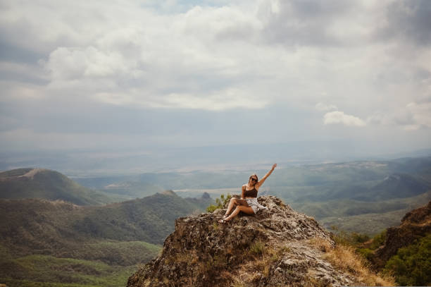 istock Young woman freelancer traveler working online anywhere outdoors using laptop enjoying mountain peak view. Happy female downshifter in sunglasses holding computer in unusual workplace at summer. 1442206069