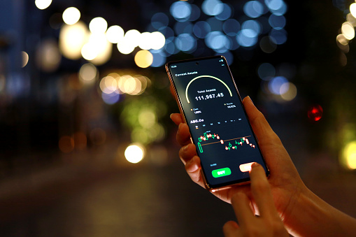 Cropped image of woman using smartphone invest online stocks trading on mobile platform app