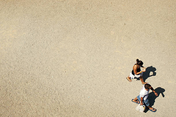 Punto di vista di due persone a piedi sulla sabbia - foto stock